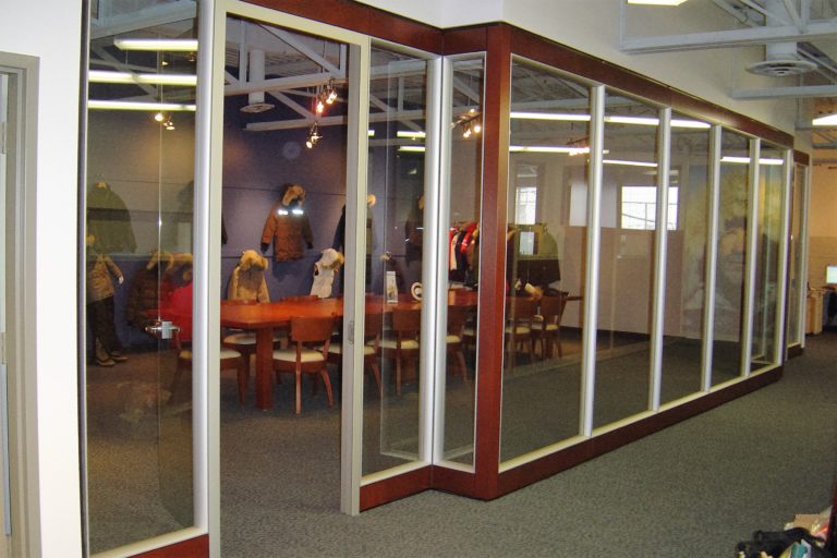 Modular glass walls with wooden frames around an office space that is under construction