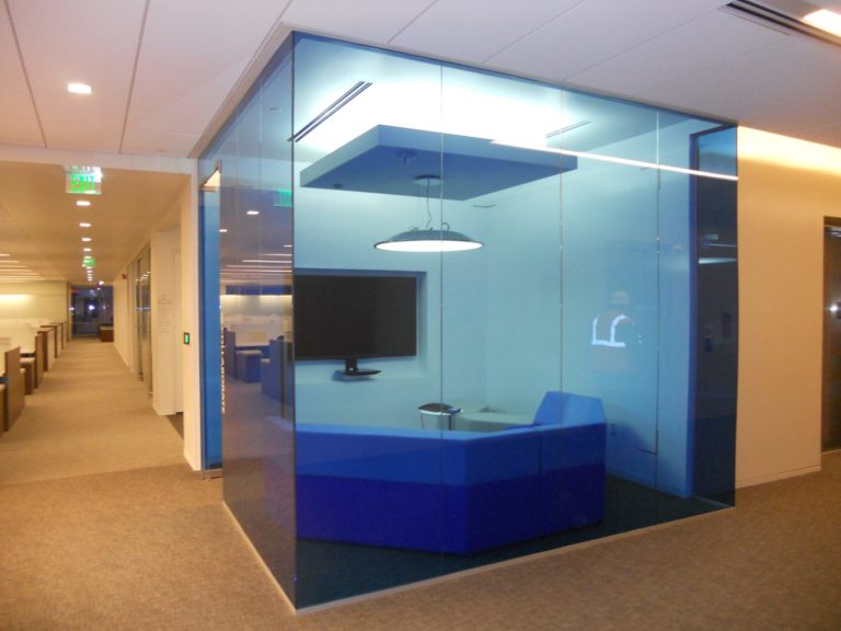 a small lounge room with blue glass walls