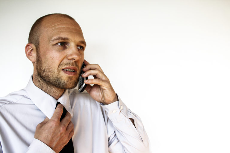 A man in a suit making a call on a cell phone
