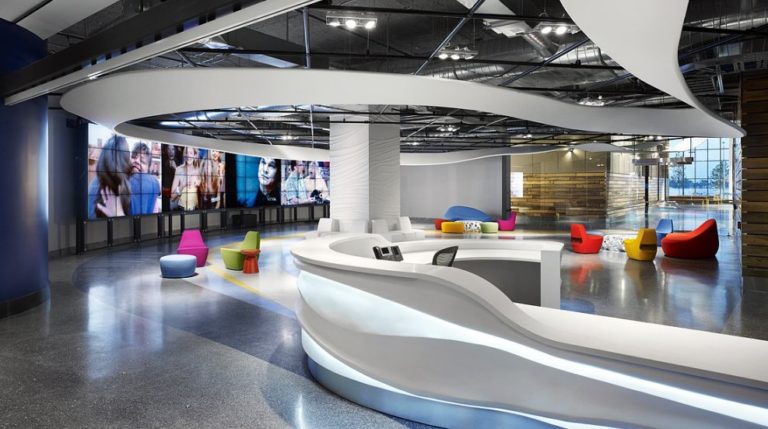 Corus Office lounge area with screens and brightly coloured furniture