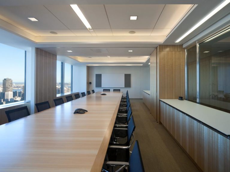 A long conference room table with chairs on either side.