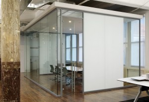 A conference room with a glass wall and a white wall