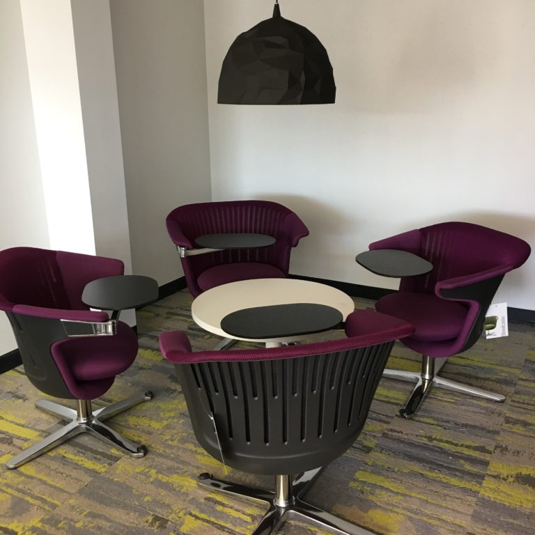 A group of burgundy chairs around a small circular table