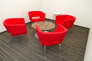 four red chairs surrounding a small wooden coffee table