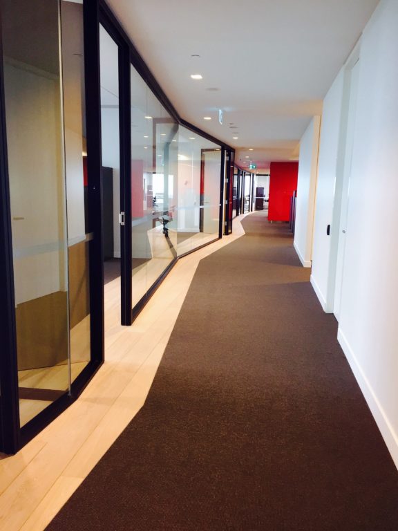 A long hallway where one side of the hall is glass panels