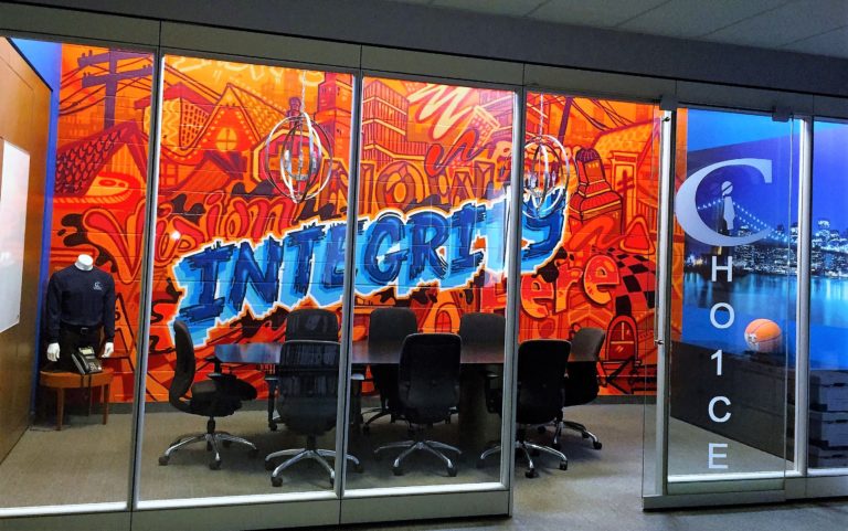 a brightly coloured office wall with the word "integrity" written in large blue letters