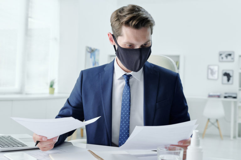 businessman in mask reading contract